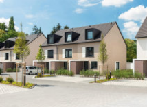 Bild von Reihenhäusern - Frontansicht mit einer Pflasterstraße und Grünflächen und Bäume